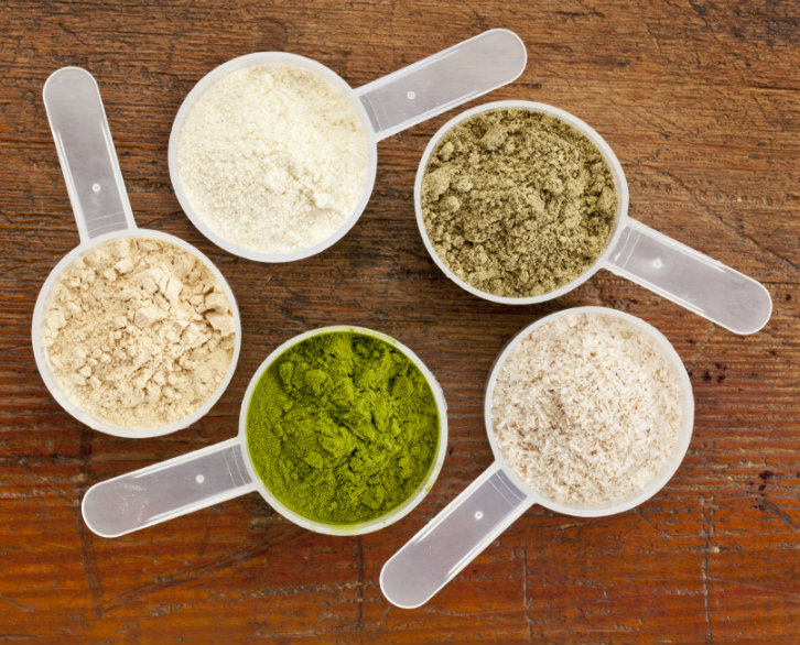 measuring cups of different superfood supplement protein powders