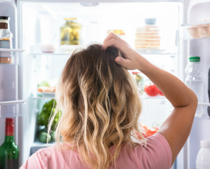 hungry woman looking in fridge after weight loss surgery