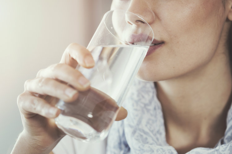 Close up of woman drinking from a glass of water